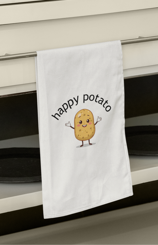 Kitchen towel with 'happy potato' design hanging on a kitchen cabinet.
