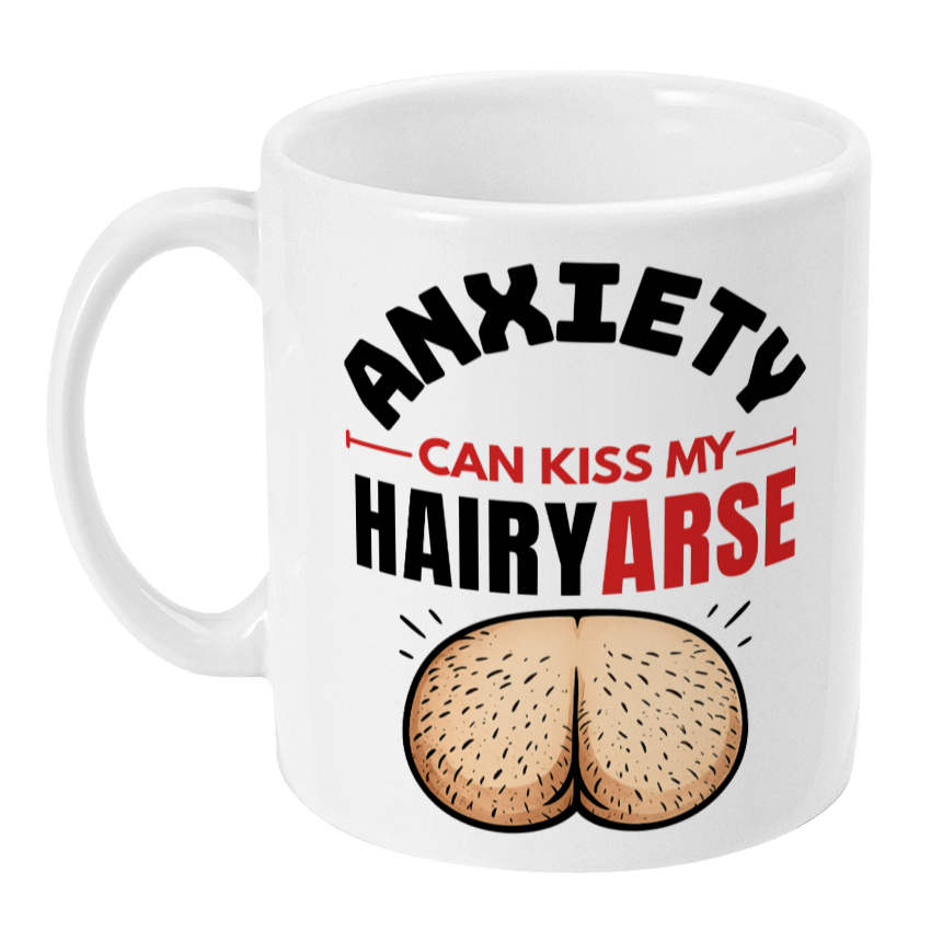 A white ceramic mug with a humorous graphic that reads 'ANXIETY CAN KISS MY HAIRYARSE' in black and red text, above an illustration of a hairy rear end, on a plain white background.