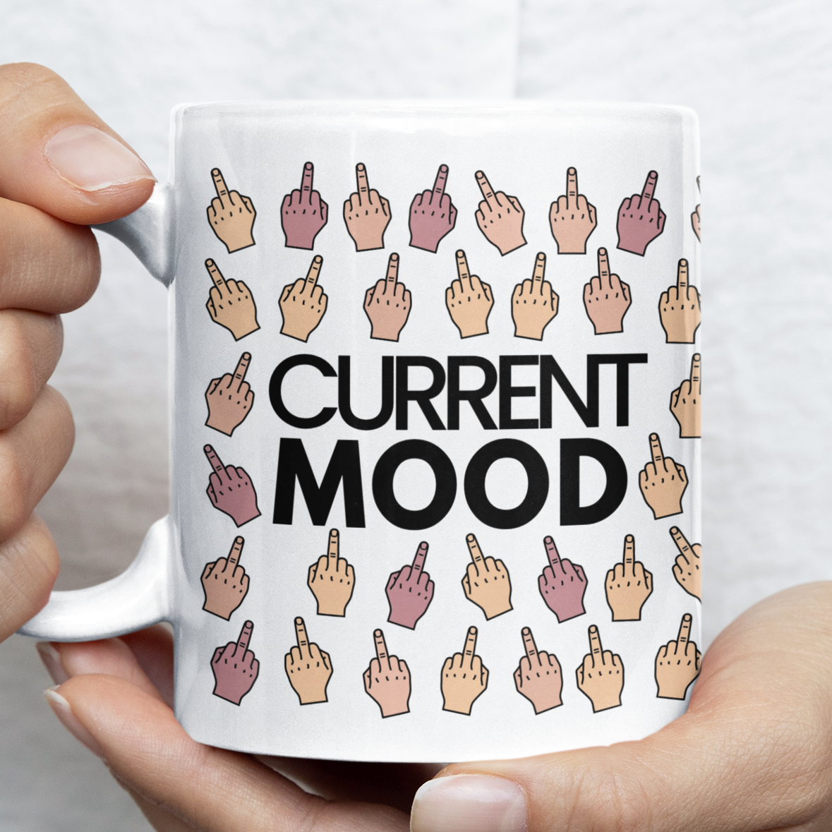 Person holding a mug with 'Current Mood' design featuring hand gestures.