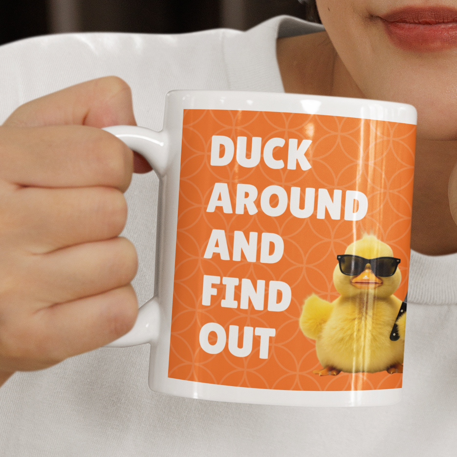 Person holding a mug with a design and text, sitting indoors.