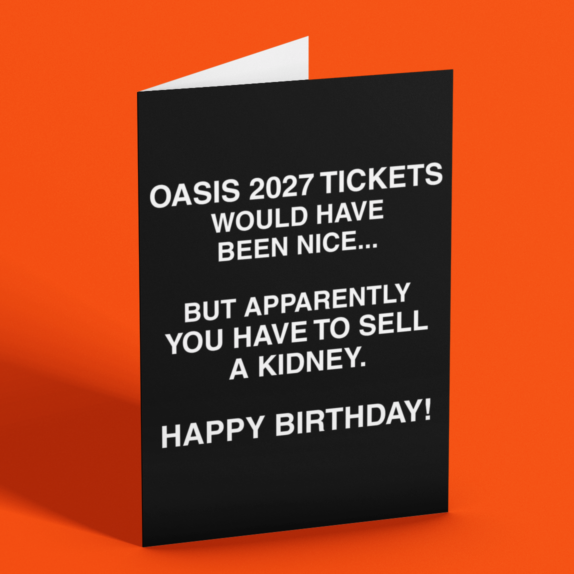 A black folded greeting card with white text that reads 'OASIS 2027 TICKETS WOULD HAVE BEEN NICE.