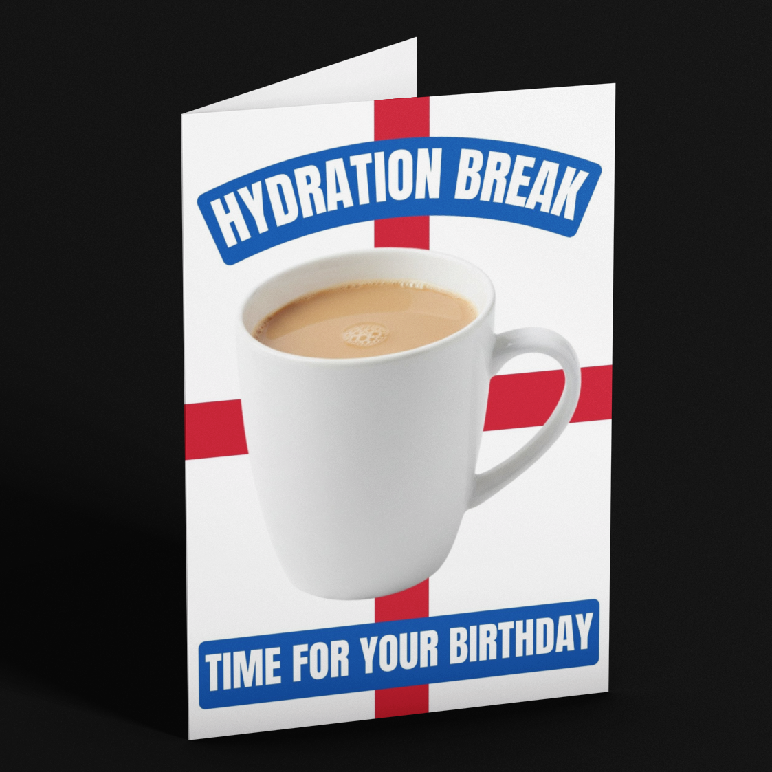 A folded greeting card standing upright on a black background. The card has a white base with a red cross design, a photo of a white coffee mug, and blue text reading 'HYDRATION BREAK' and 'TIME FOR YOUR BIRTHDAY'.