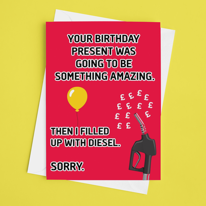 A red greeting card with a humorous diesel birthday message, shown with a white envelope on a bright yellow background. The card features a yellow balloon, white text, and a black fuel pump illustration.