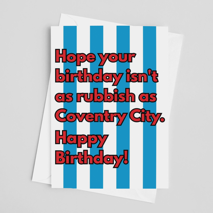 A birthday greeting card with bold red text reading 'Hope your birthday isn't as rubbish as Coventry City. Happy Birthday!' over vertical blue and white stripes, shown on a light gray background.