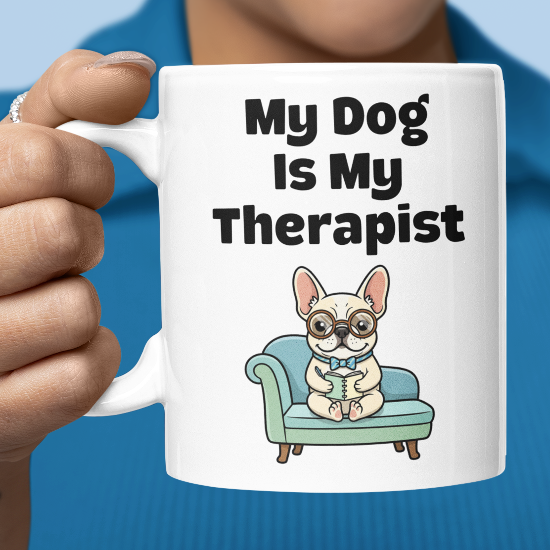 Person holding a mug with a dog illustration and text 'My Dog Is My Therapist' against a blue background