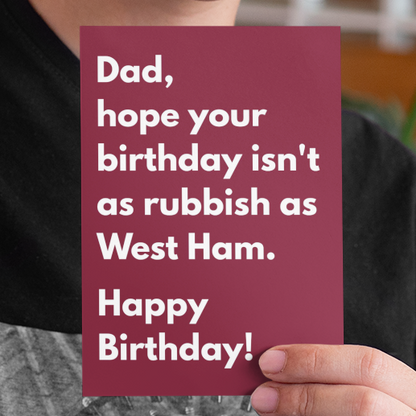 Person holding a birthday card with humorous message in an indoor setting