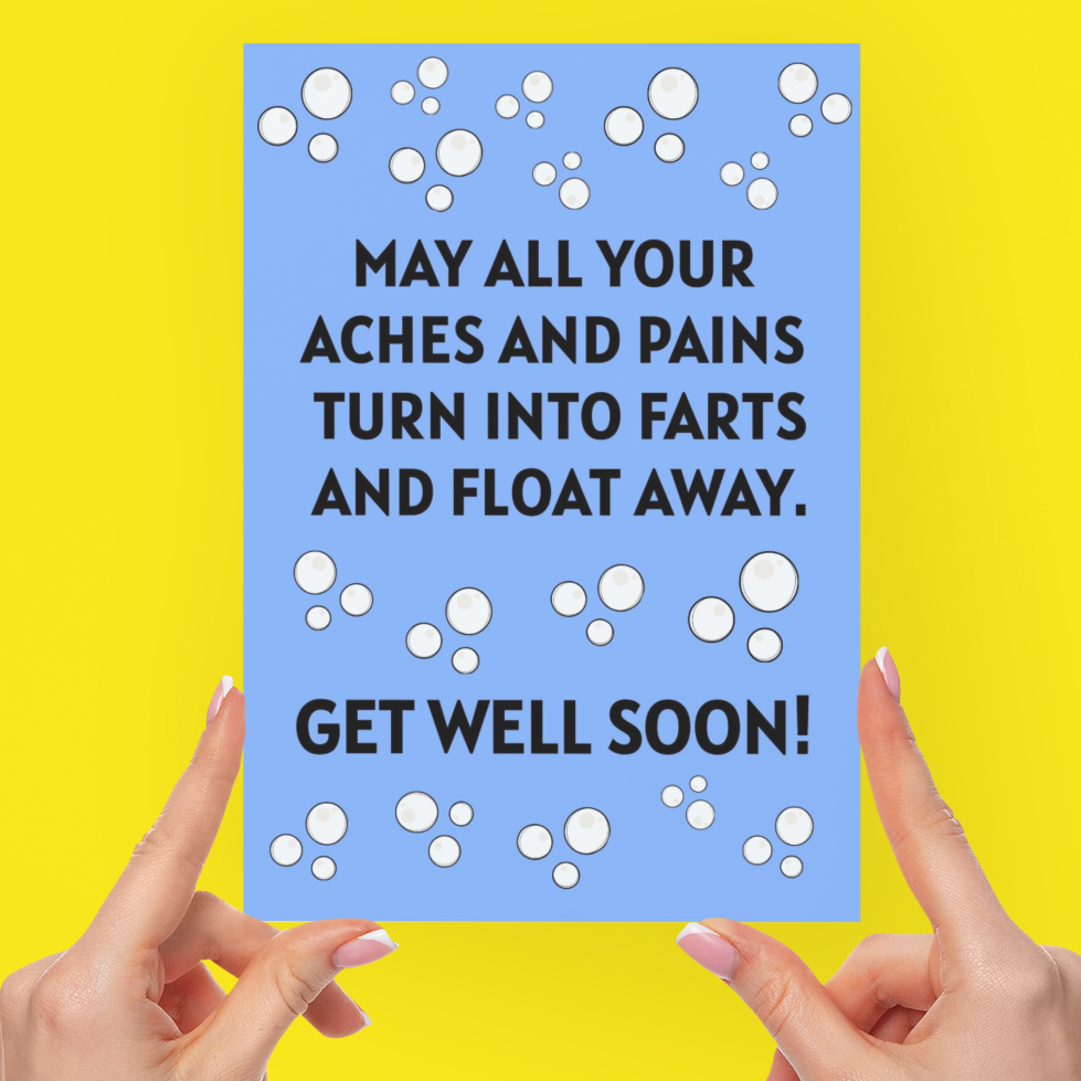 A person holds a light blue greeting card with black text and white bubble illustrations against a bright yellow background. The card reads, 'MAY ALL YOUR ACHES AND PAINS TURN INTO FARTS AND FLOAT AWAY.
