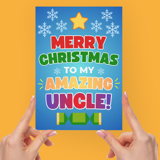 A person holds a colorful Christmas greeting card that reads 'MERRY CHRISTMAS TO MY AMAZING UNCLE!' against a solid orange background.