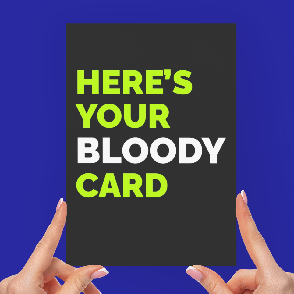 A person holds a dark rectangular card with the text 'HERE'S YOUR BLOODY CARD' in bright green and white lettering against a solid blue background.