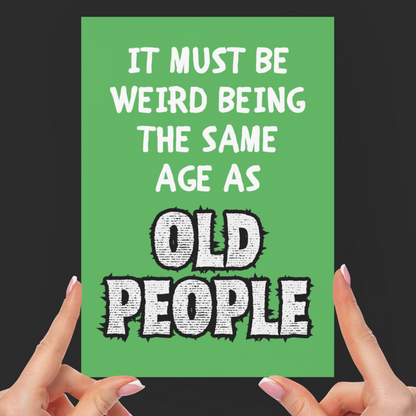 Green card with humorous text held by hands against a black background