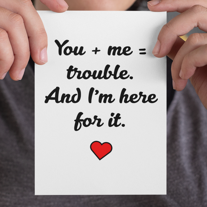 Person holding a card with a romantic message and heart symbol.