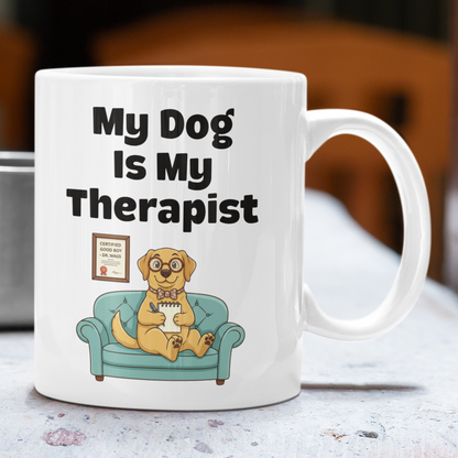 Mug with 'My Dog is My Therapist' text and a dog illustration on a table.